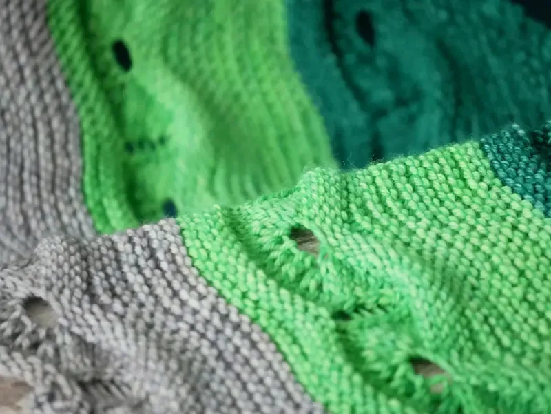 Close up of eyelet pattern on a background of garter stitches.